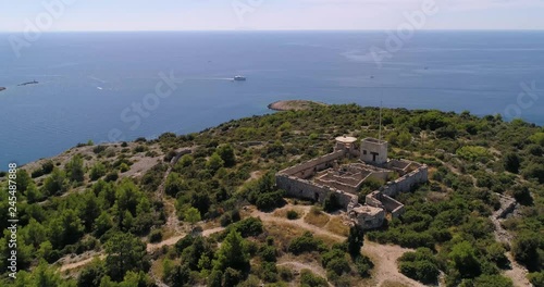 Mediterranean coast, C4k aerial, orbit, drone shot, on the top of a hill, overlooking of small croatian islands and a ferry, on the adriatic sea, on a sunny, summer day, in Croatia