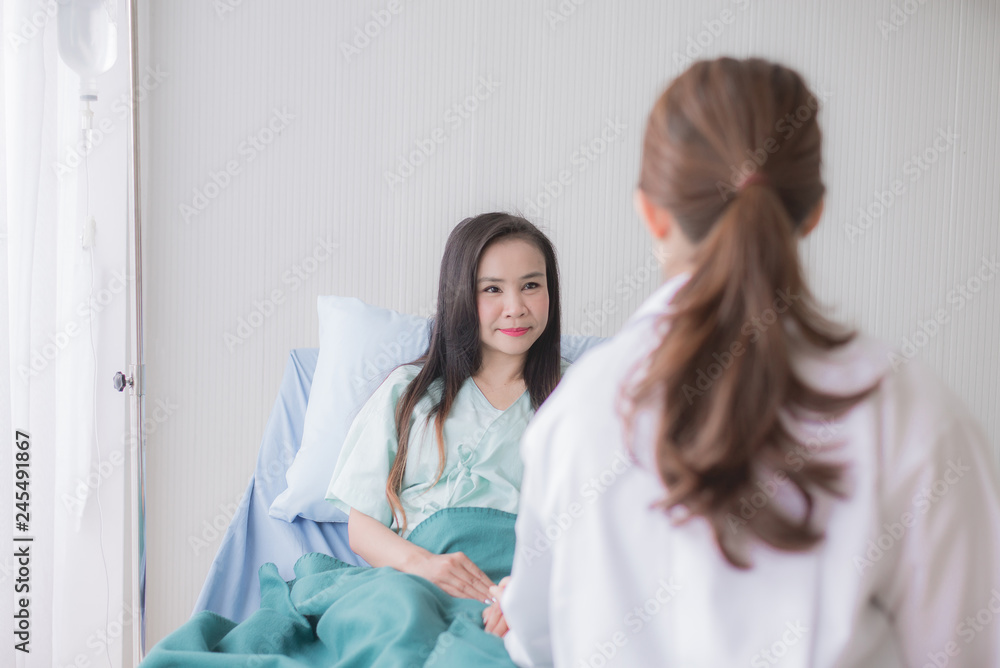 Obraz premium Hands women doctor reassuring her female asian patient in hospital room,Dentist giving a consultation and encouragement to patient