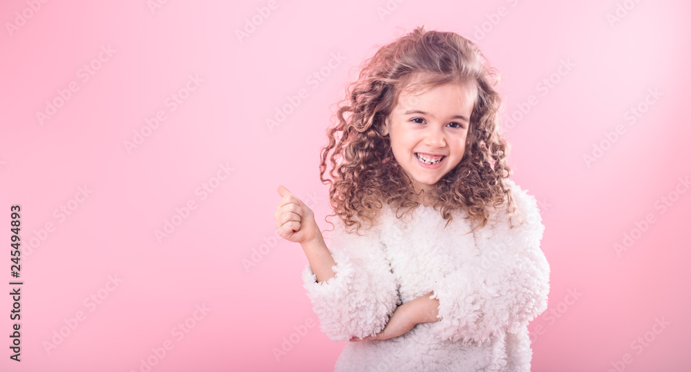 Portrait of girl pointing finger at up on pink Portrait of girl pointing finger at up on pink