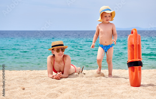 Toddler boy on beach with mother