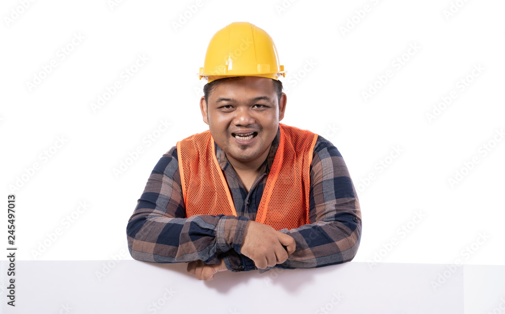 portrait of happy handyman with helmet and uniform leaning on white board portrait of happy handyman with helmet and uniform leaning on white board