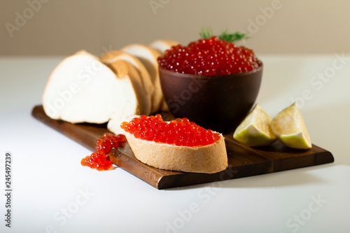 Wallpaper Mural red caviar in a ceramic dish on a wooden platform on a white background Torontodigital.ca