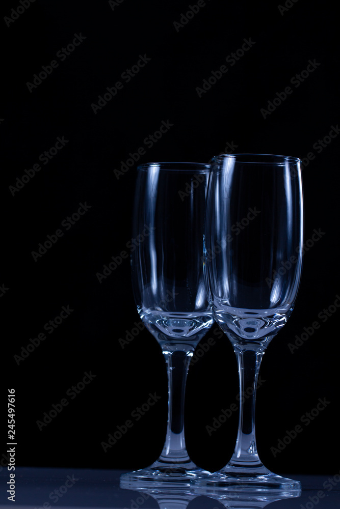 empty wine glass close-up on a black background with a place for text on the background of Christmas lights