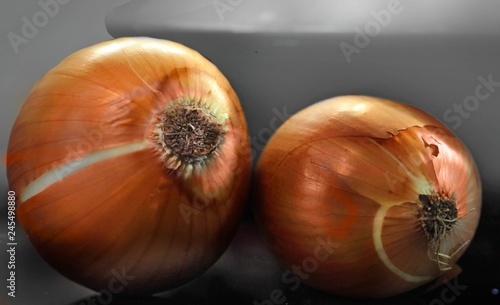 Two large yellow onions lying on the table