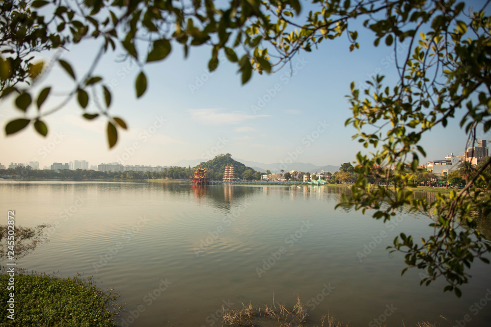 Fototapeta premium Foliage frames temples and pagodas in the distance across lake in Kaoshiung