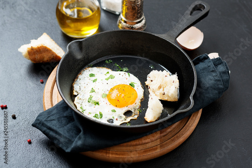 Fried egg for delicious healthy easy breakfast on a table. Fresh homemade meal on a frying pan.