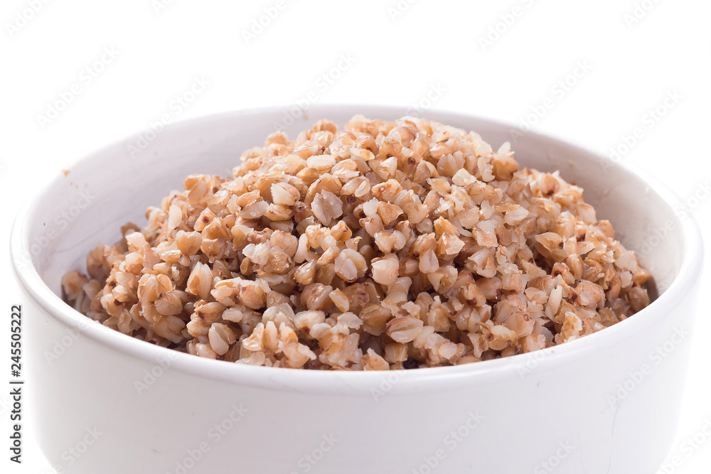 Boiled buckwheat in white plate on white isolated background Boiled buckwheat in white plate on white isolated background