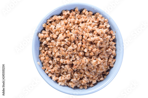 Boiled buckwheat in blue plate top view on white isolated background
