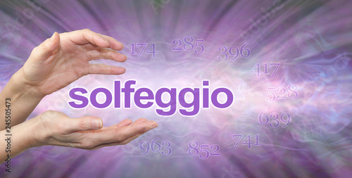 Solfeggio Hertz Frequencies banner - female hands with the word SOLFEGGIO floating between surrounded by the 9 healing frequencies on a purple lilac radiating sound wave background 