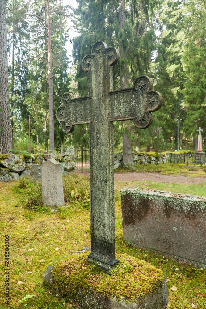 Cross at old semetery in Finland with grave crosses and stones. Cross at old semetery in Finland with grave crosses and stones.