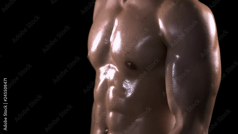 Muscle man doing exercise with dumbbells in the studio. Shot in 4k resolution with dark background Muscle man doing exercise with dumbbells in the studio. Shot in 4k resolution with dark background