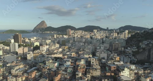 Sunny daytime aerial retreating over the Santo Amaro favela in Rio de Janeiro Brazil with the Sugarloaf mountain and Guanabara Bay in the background photo