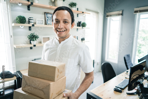 portrait of asian young man with boxes package 