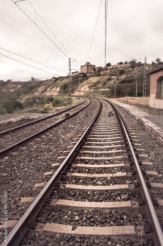 RAILES DE FERROCARRIL Y HORIZONTE CON COLINA Y EDIFICIOS 