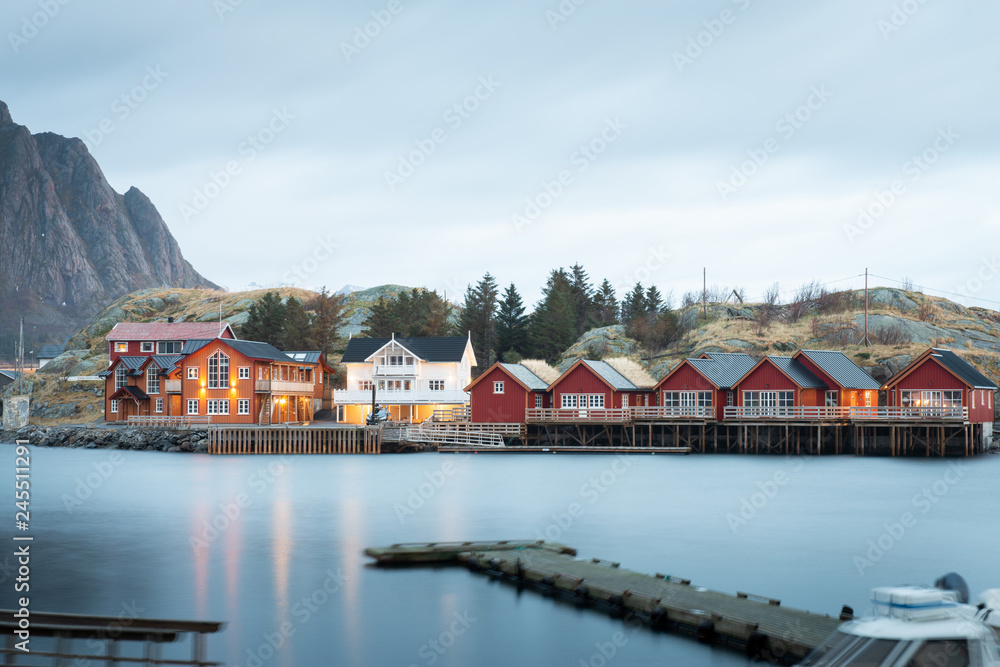 Long exposure of dock with fishing rorbuer house village in Lofoten island Hamnoy Norway