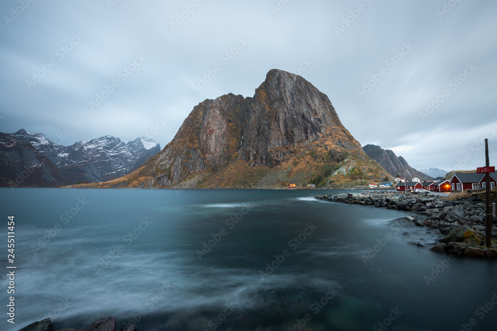 Long exposure of red fishing rorbuer house village with mountain view in Lofoten island Hamnoy Norway