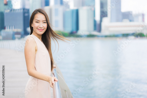 Beautiful asian woman smile and happy to travel in singapore city