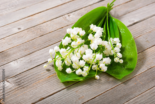 bouquet of lily of the valley on old weathered wooden table background