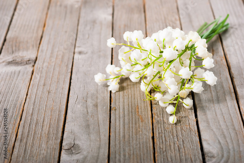 bouquet of lily of the valley flowers on old weathered wooden table background