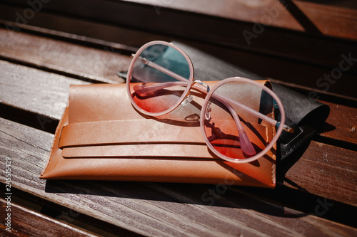 stylish sunglasses and a cover for glasses on a wooden background