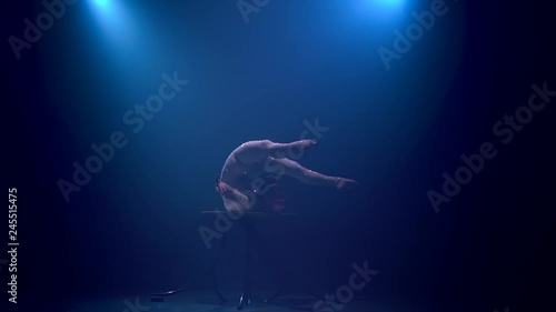 Wallpaper Mural Gymnast performs tricks on the table in the studio. Smoke blue background. Slow motion Torontodigital.ca