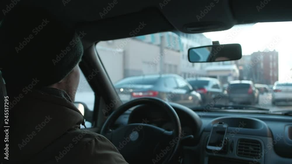 back view - the man drive the car in city, during the cold season. 4k. taxi driver at work. back view - the man drive the car in city, during the cold season. 4k. taxi driver at work.
