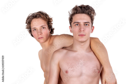 Two young sexy guys hugs on a white background. Love, passion and relationships