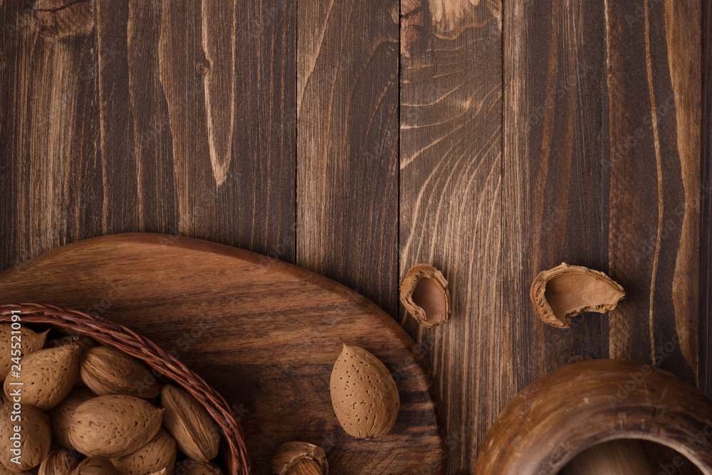 Flat lay of almonds in the wicker plates with other accessories on brown wooden background top view 12 Flat lay of almonds in the wicker plates with other accessories on brown wooden background top view 12