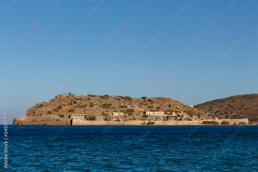 View over the island of Spinalonga, Crete, Greece. Ruins of ancient Venetian medieval fortress. It was the last leper colony in Europe. People with the Hansen's disease lived here.