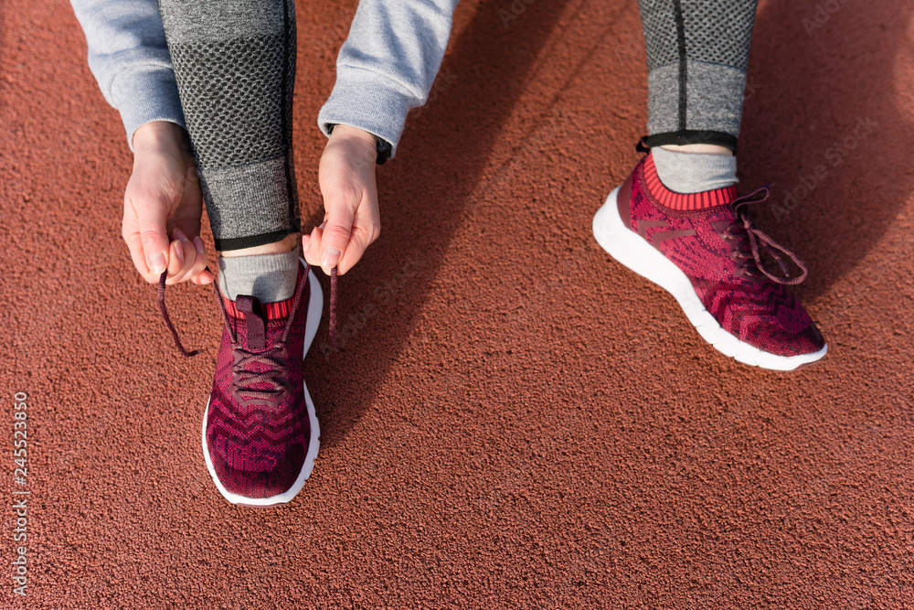 Shot of athletic woman tying she is shoelaces before a run.