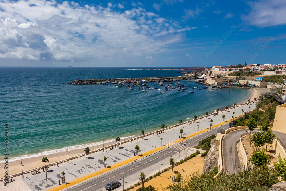 Panorama view over Vasco da Gama beach and town of Sines. Turquoise water. Moody sky, clouds.