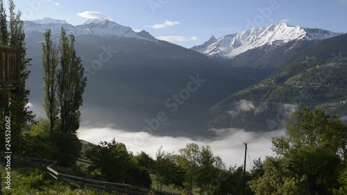 view above clouds on alpine mountains in park of the vanoise snowy peak photo