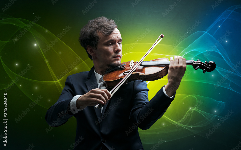 Fototapeta premium Serious classical violinist with fabled sparkling wallpaper