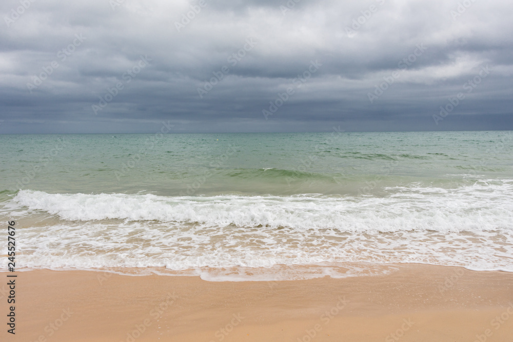 Sandy beach before the rain. Dark clouds over the ocean and the beach. Sandy beach before the rain. Dark clouds over the ocean and the beach.