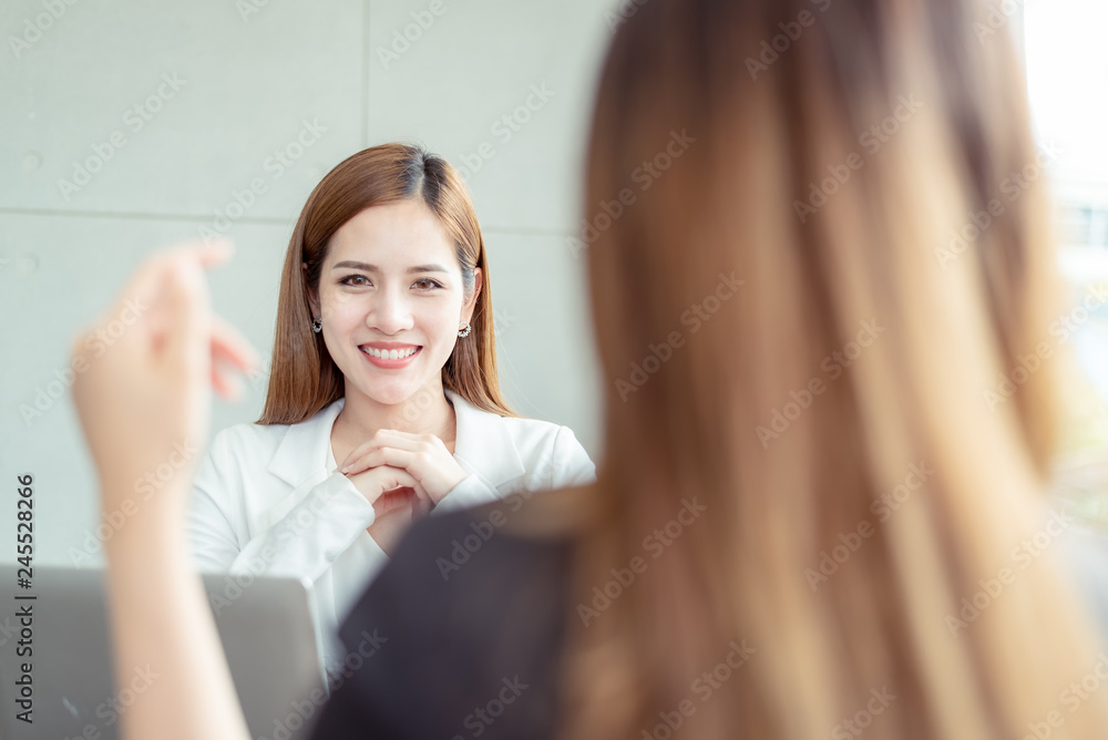 Closed up of Two confident asian business women entrepreneurs beautiful smile young financial assistant business woman while talking with colleague team at the modern office interior.