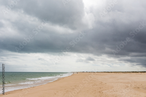 Sandy beach before the rain. Dark clouds over the ocean and the beach.