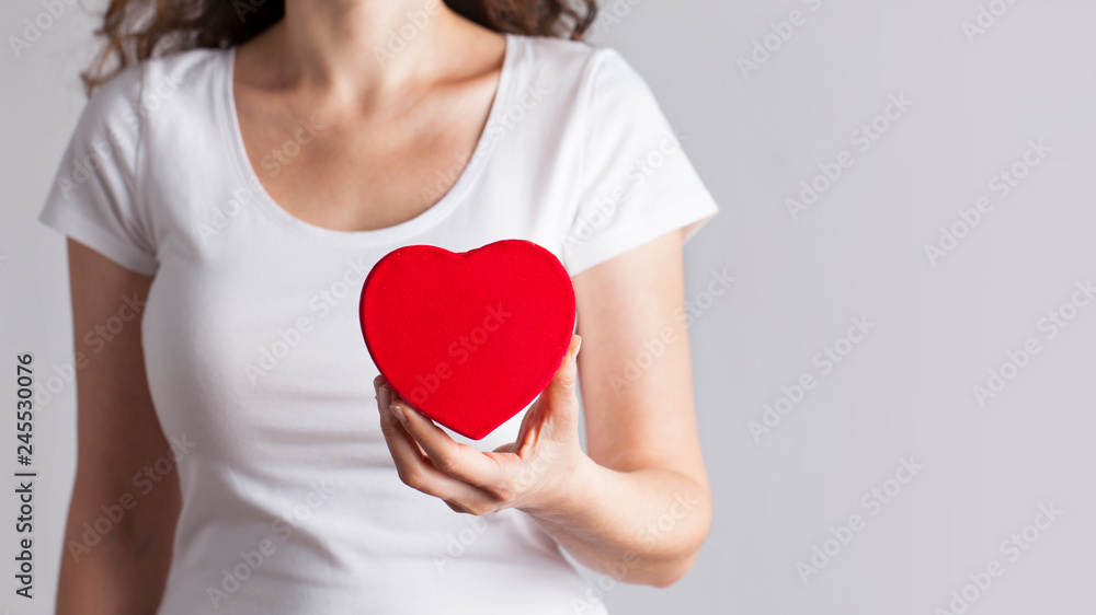 Young woman holding red heart, health insurance, donation, love concept Young woman holding red heart, health insurance, donation, love concept