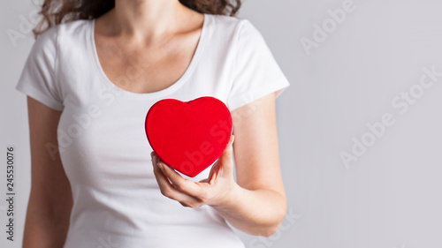 Young woman holding red heart  health insurance  donation  love concept