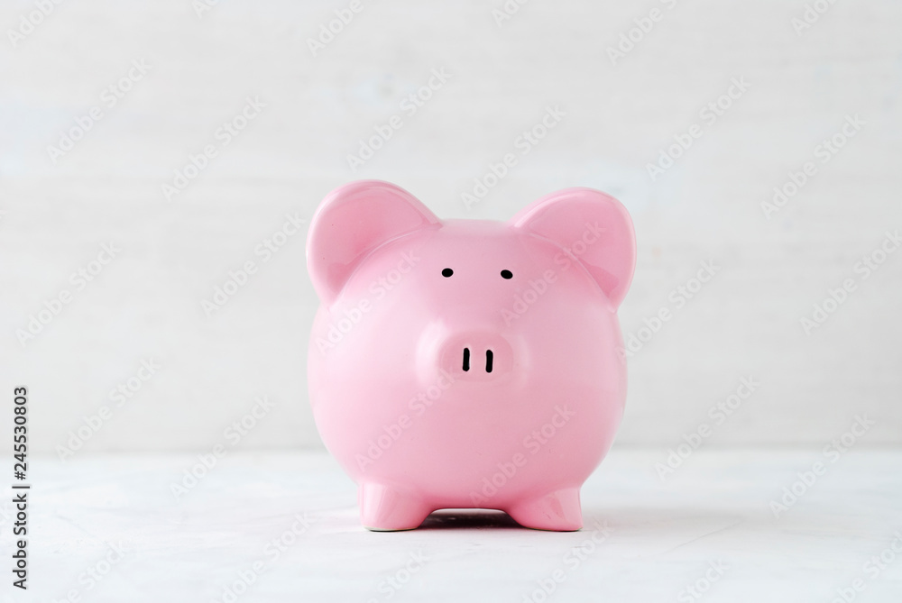 Pink piggy bank over a light off white background