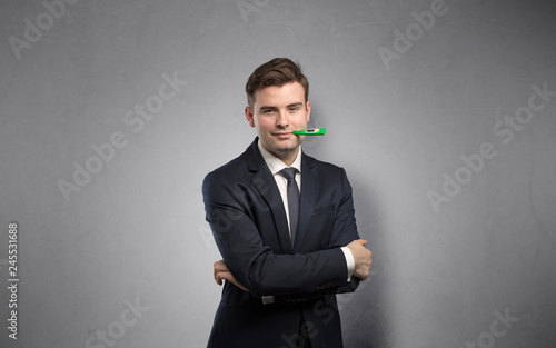 Young tired businessman with thermometer and copy space 