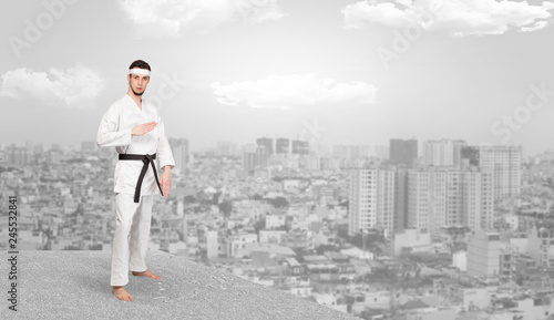 Young karate trainer doing karate tricks on the top of a metropolitan city 