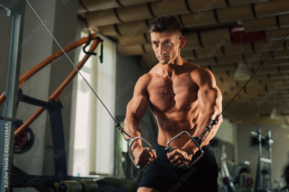 Young fit man doing maching chest exercises in the gym Young fit man doing maching chest exercises in the gym