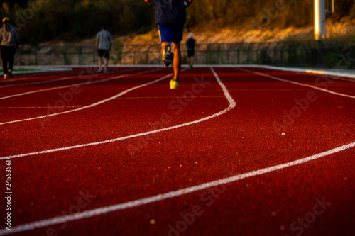 Red running track with runner's feet. Sport stadium for run.