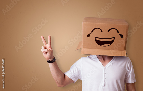 Funny man wearing cardboard box on his head with smiley face 