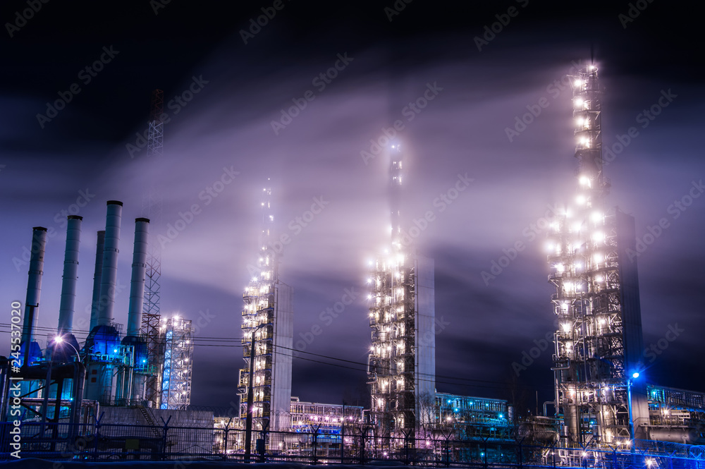 Fototapeta premium Chemical industry distillation towers detail at night. Petrochemical background. Long exposure at winter dusk.