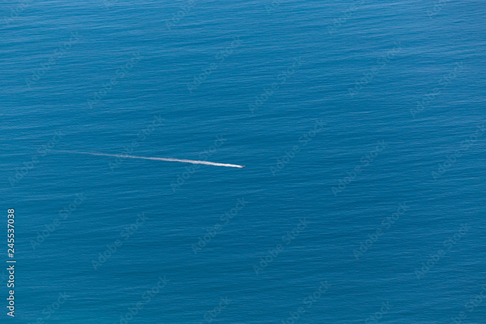 Aerial view of small boat flowing in the ocean, minimalistic travel concept Aerial view of small boat flowing in the ocean, minimalistic travel concept