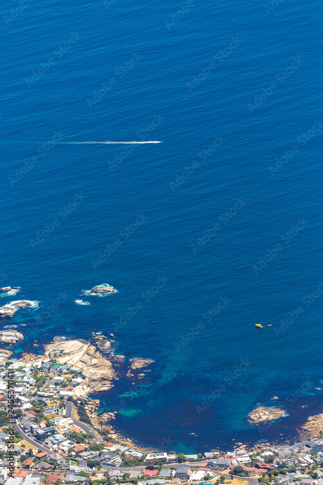 Aerial view of small boat flowing near the coast in Cape Town, South Africa