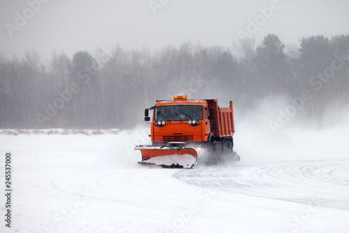 Snowplow cleaning road during winter snow storm