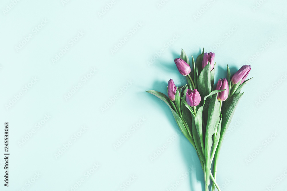 Flowers composition. Purple tulip flowers on pastel blue background. Valentines day, mothers day, womens day concept. Flat lay, top view, copy space