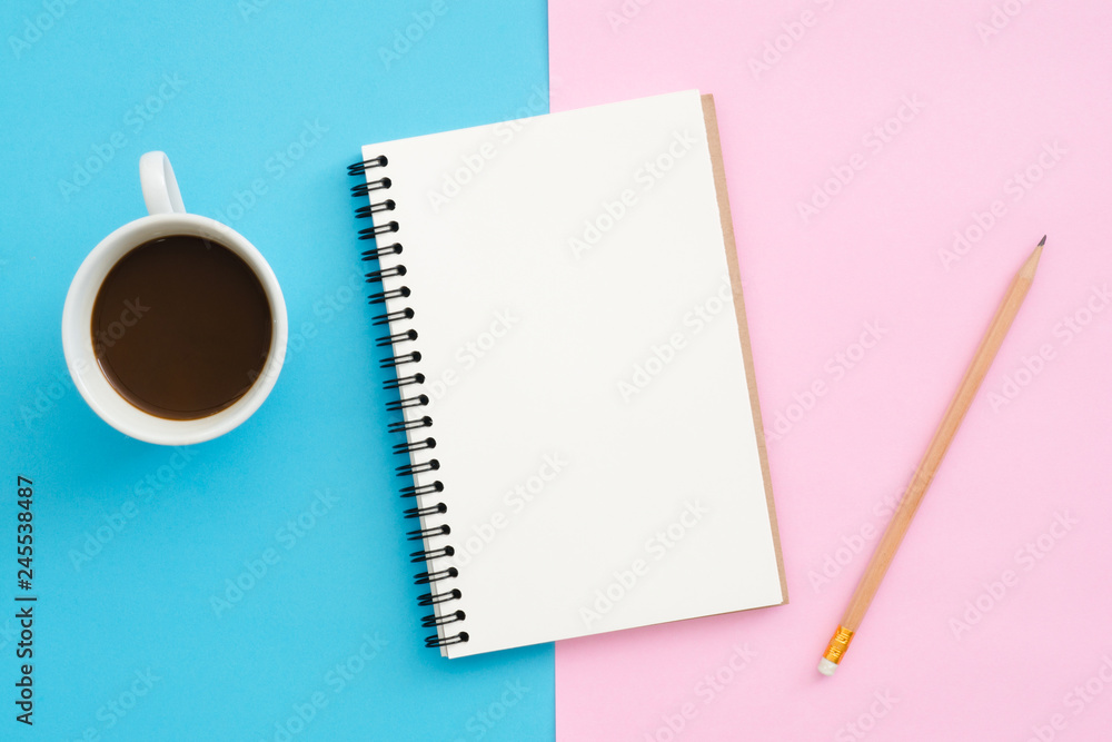 Creative flat lay photo of workspace desk. Top view office desk with pencil, notebook and coffee cup on blue pink color background. Top view with copy space, flat lay photography. Creative flat lay photo of workspace desk. Top view office desk with pencil, notebook and coffee cup on blue pink color background. Top view with copy space, flat lay photography.